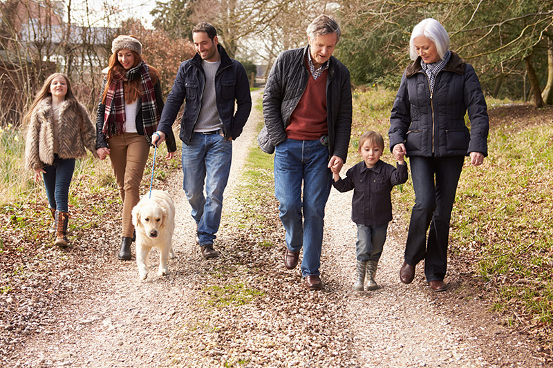 Multi Generational Family walking in the fall with grand kids and dog.